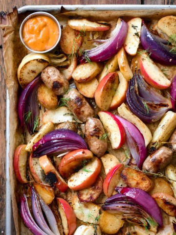 A sheet pan with roasted apples, fennel, onions and sausages.