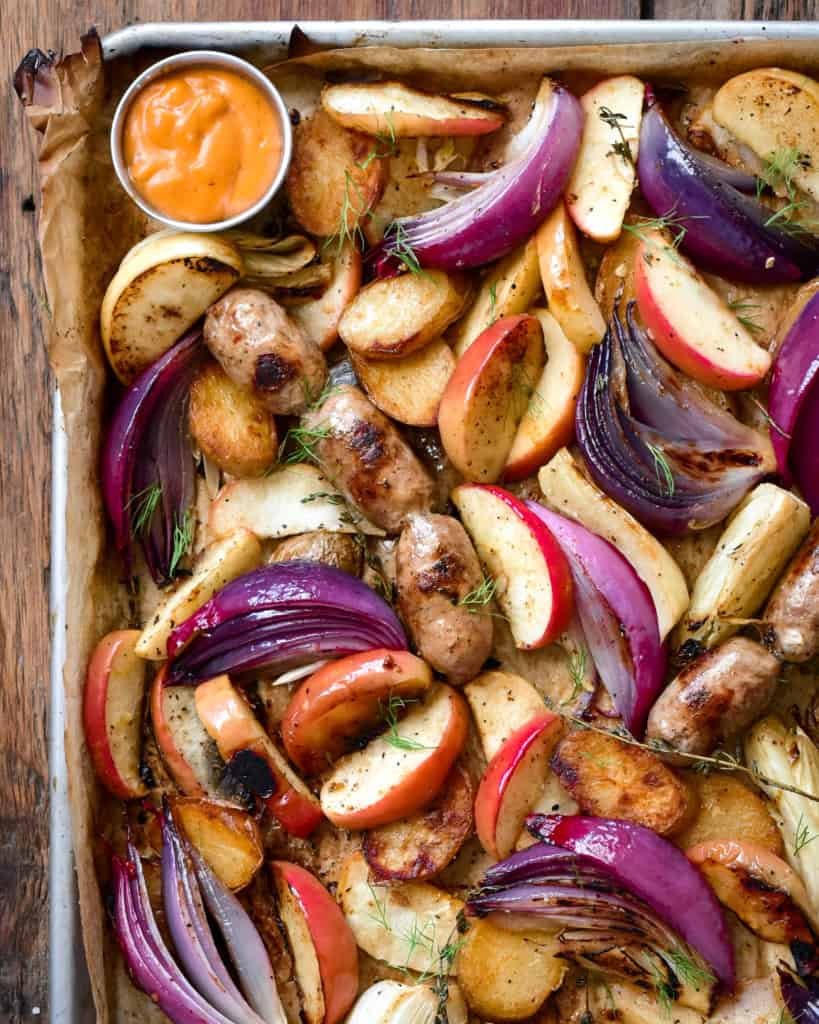 A sheet pan with roasted apples, fennel, onions and sausages.