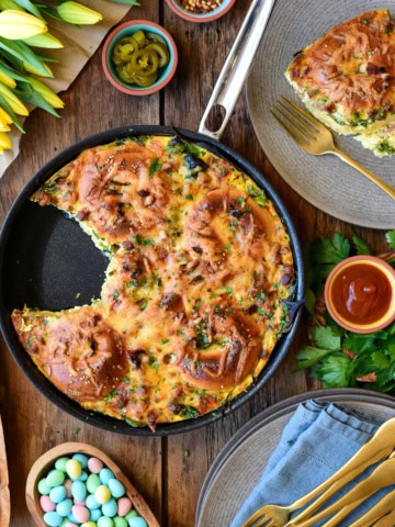 A bagel bake skillet bake with a piece removed and on a plate.
