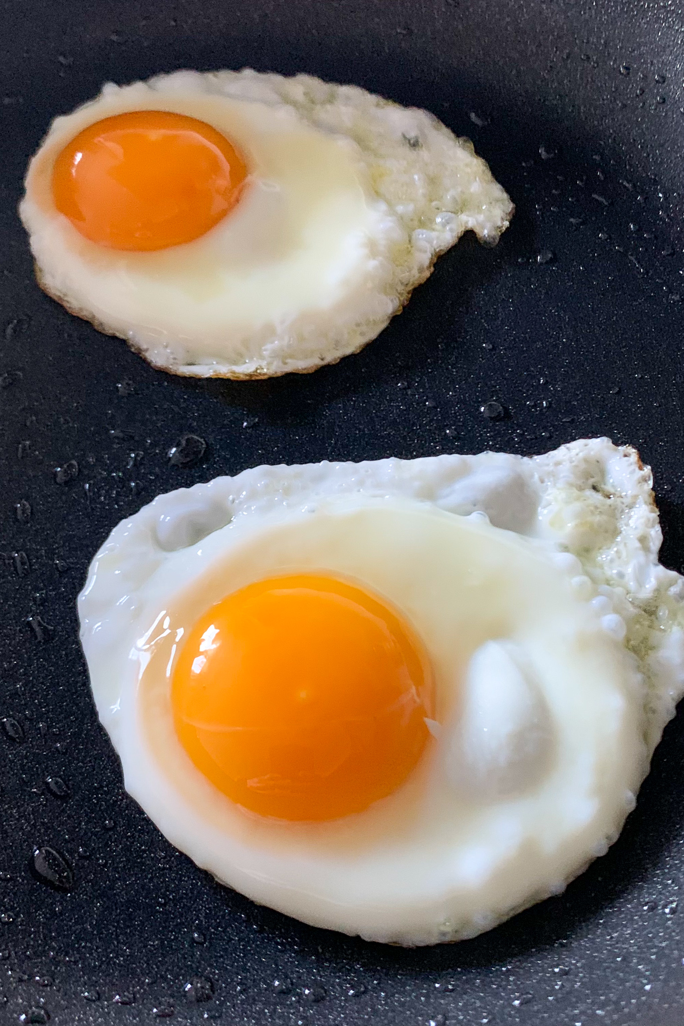 An image of two perfect sunny side up eggs