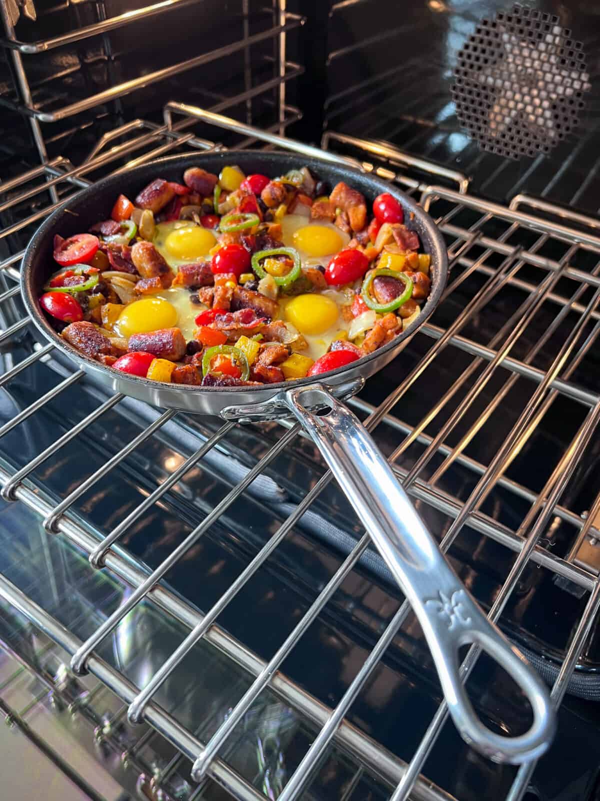 A one skillet hash going in an oven with eggs just added ready to be baked.
