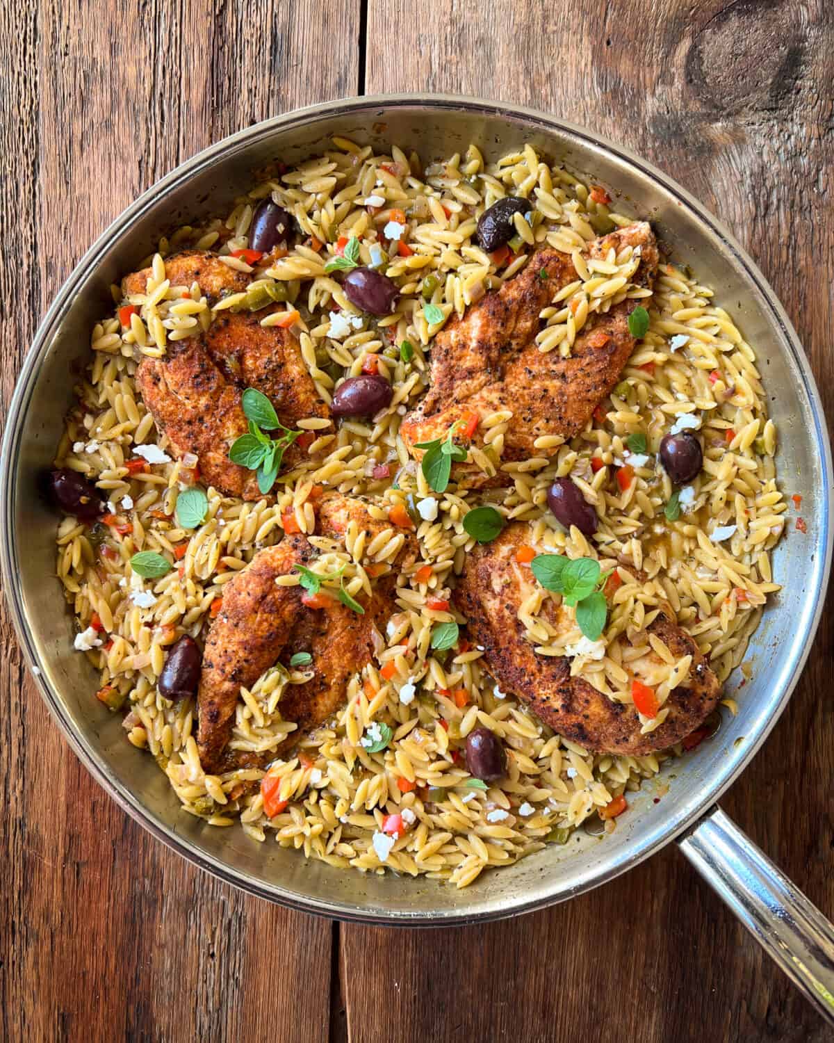 A top down image of a chicken and orzo one pan meal.