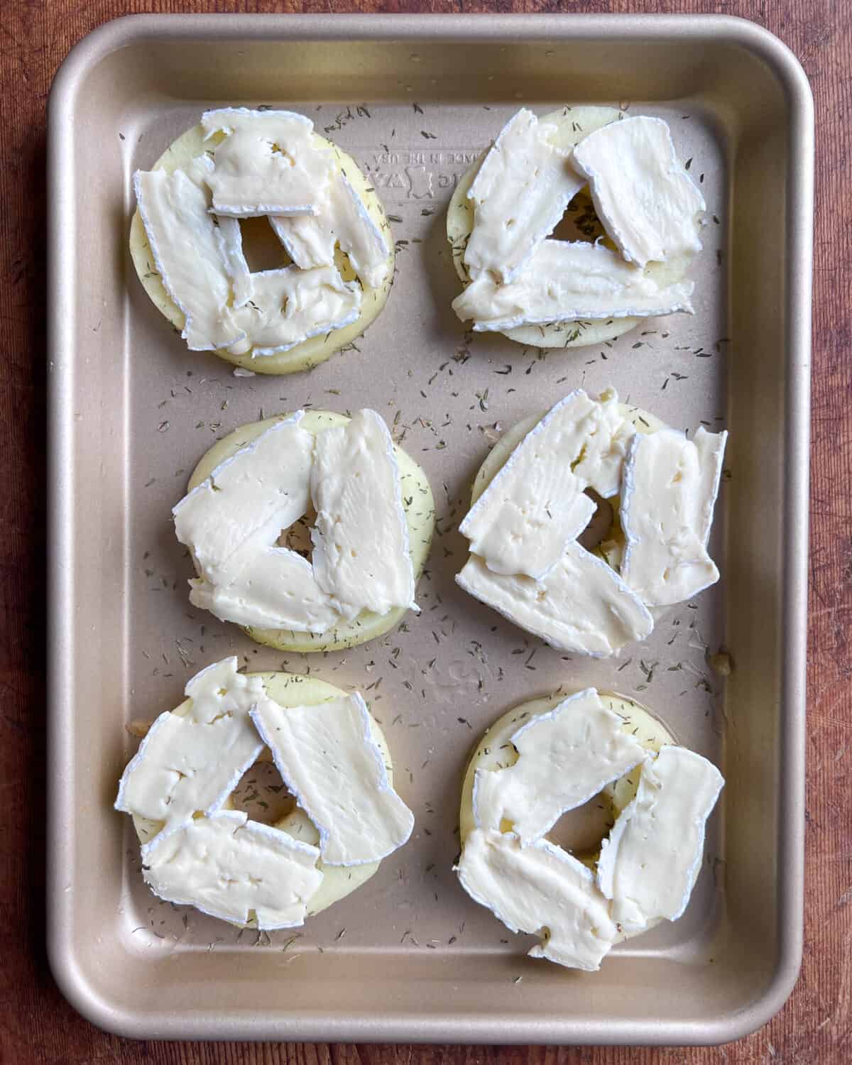 Six apple slices with three pieces of Brie on each apple.