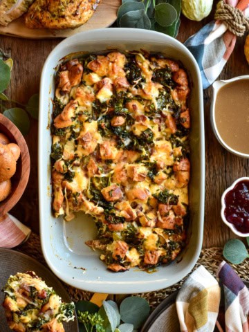 A retangular baking dish with a savoury bread pudding served with gravy and cranberries.