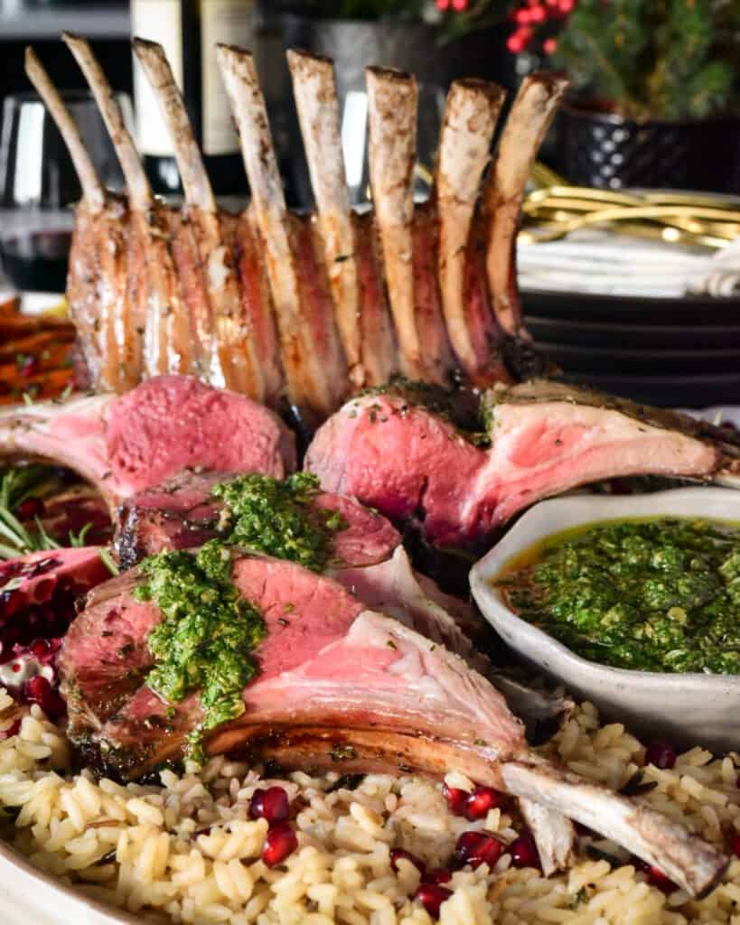 A slice crown rack of lamb on with a mint salsa verde.