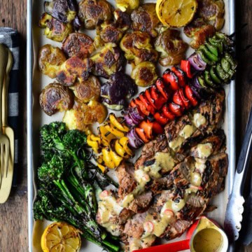 A colourful platter of Spicy Maple Pork Tenderloins, skewered vegetables, smashed potatoes and broccolini.