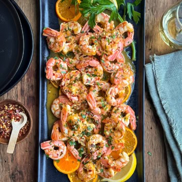 A citrus shrimp dish with clementine and lemon slices.
