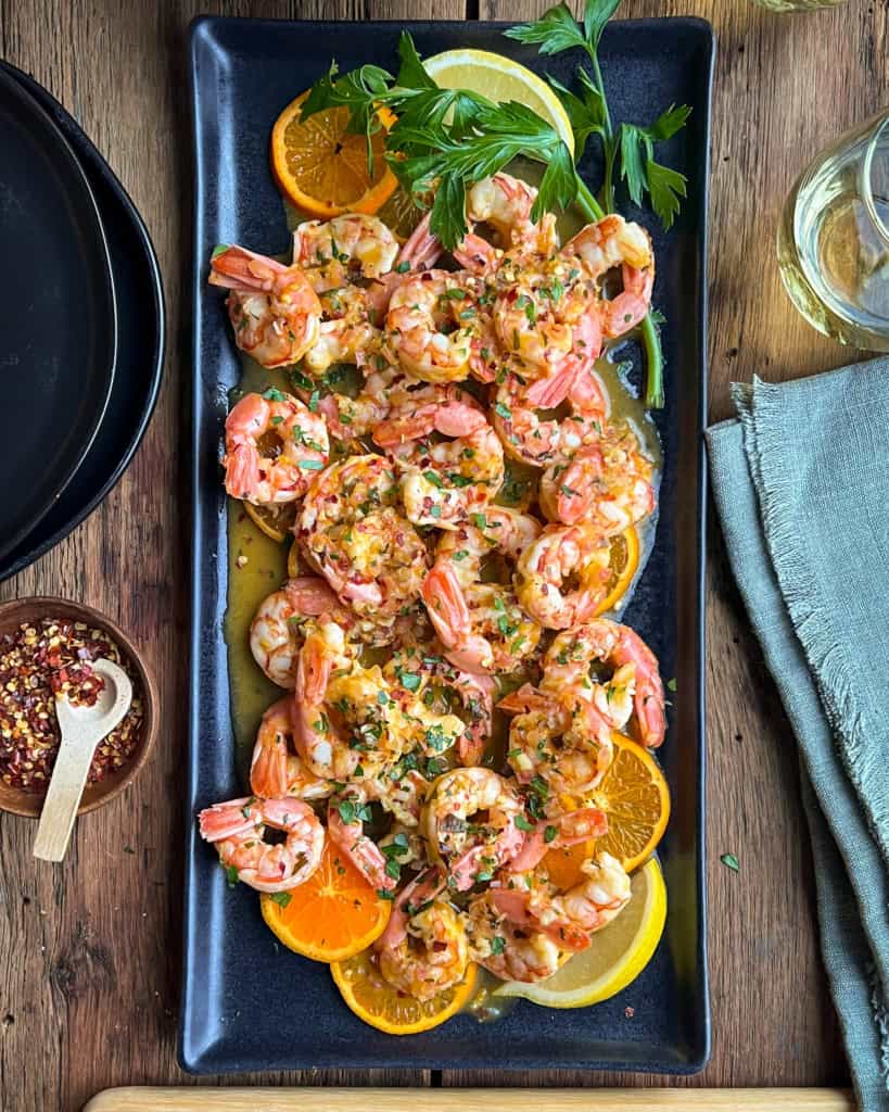 A citrus shrimp dish with clementine and lemon slices.