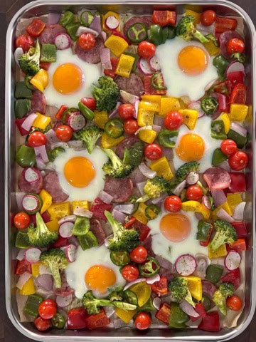 An easy and colourful one sheet pan meal that is packed with veggies, eggs and kielbasa.
