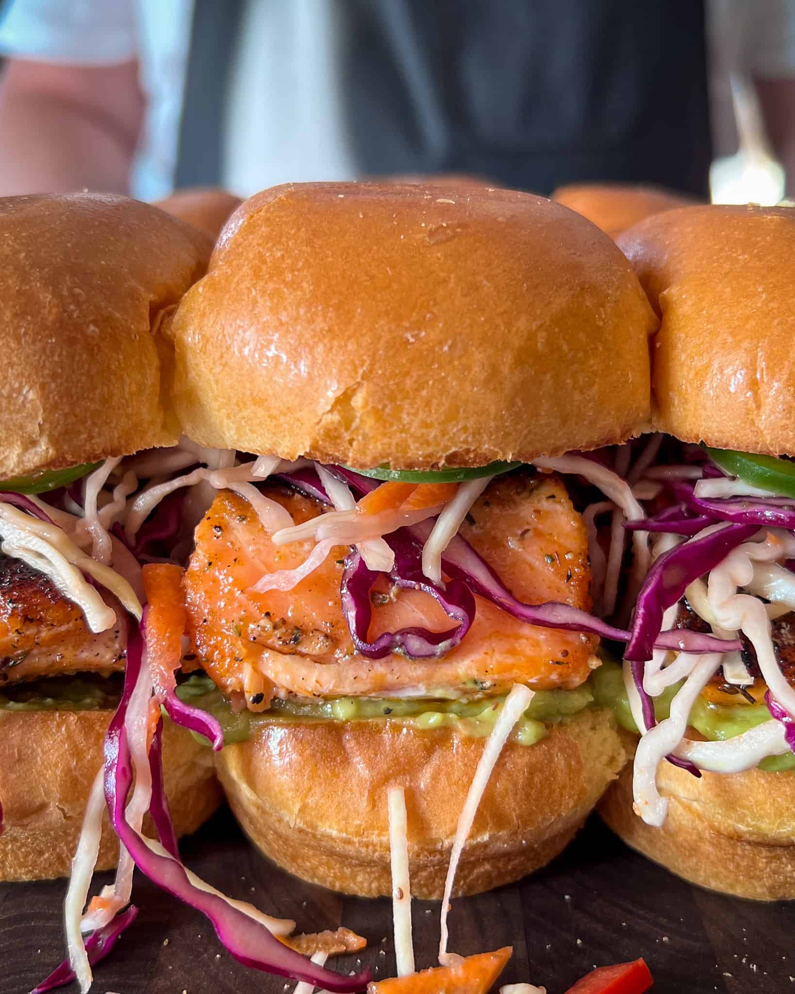 A close up of blackened Salmon sliders with a rainbow slaw.
