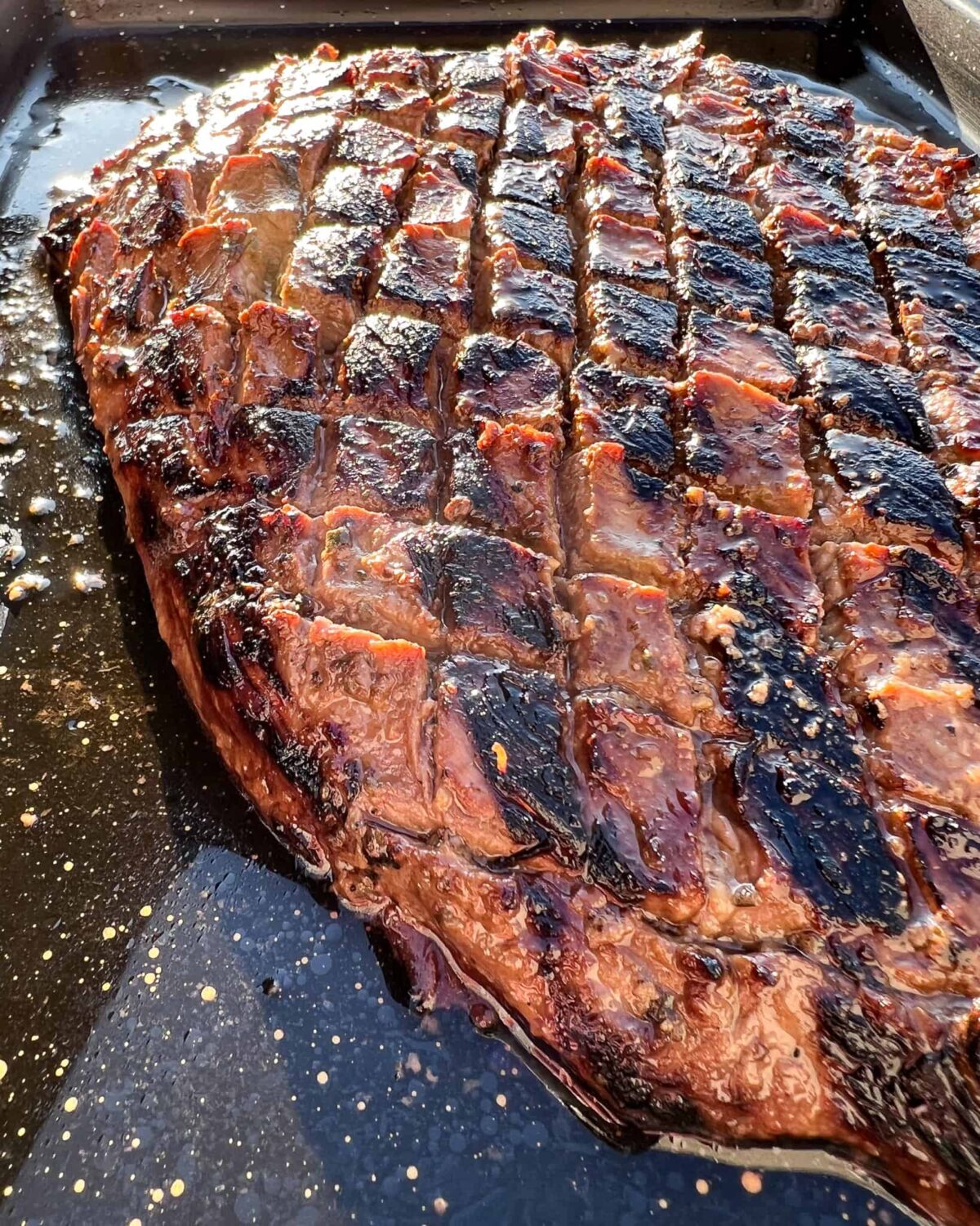 A seared flank steak with horizontal crosshatching.