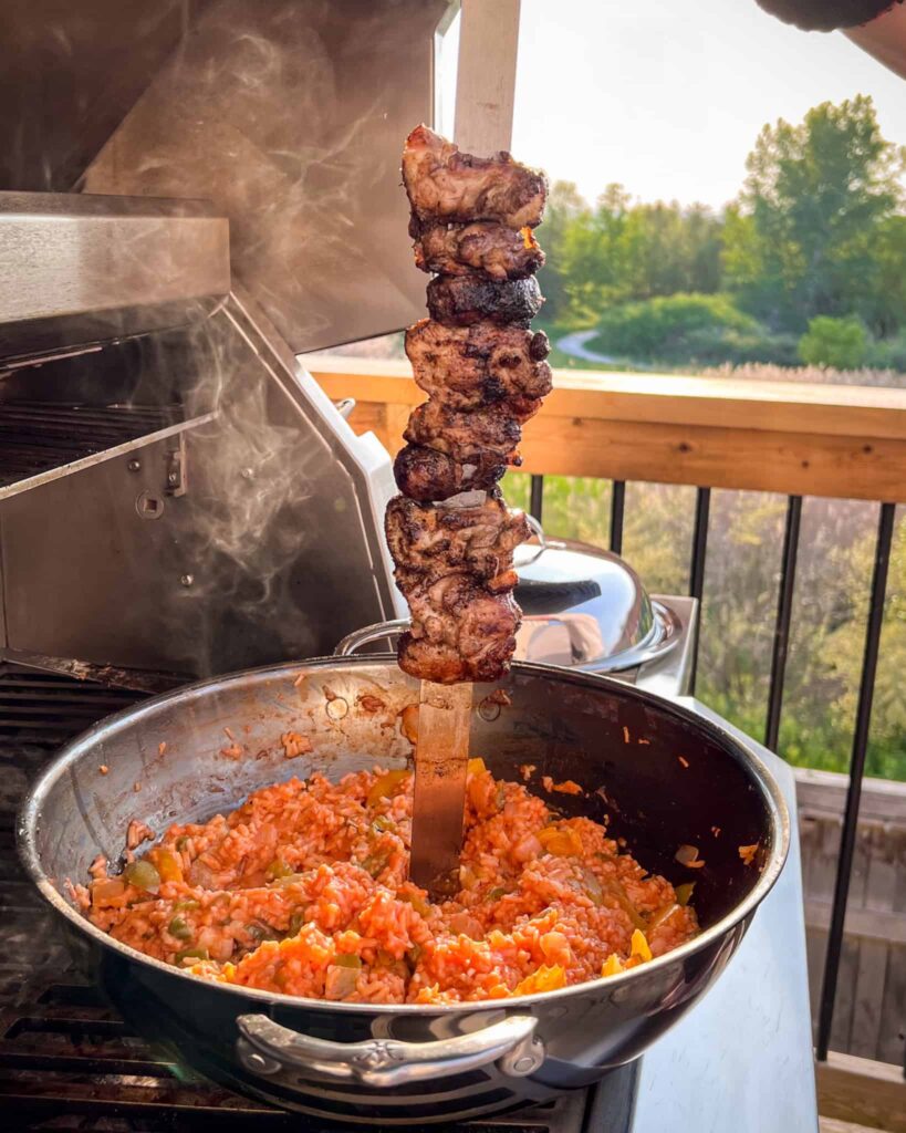 Place the skewers above the wok, remove the lid (careful, it is hot) and let the drippings fall into the rice.