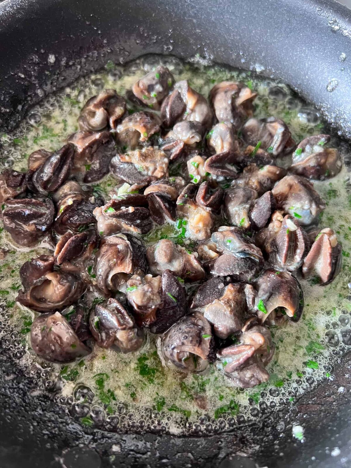 Snails (escargot) getting warmed up in butter.