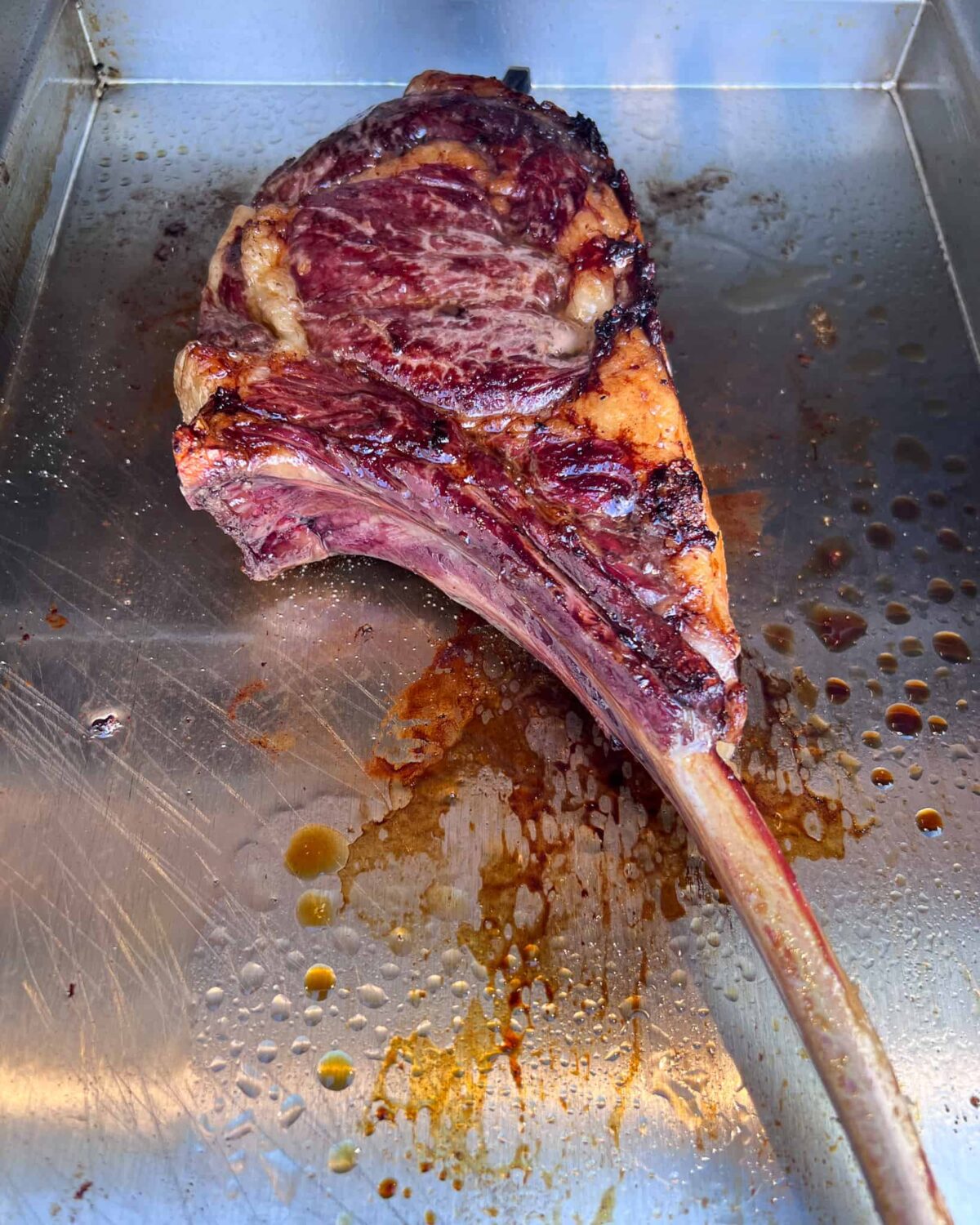 A ribeye steak getting the final sear.