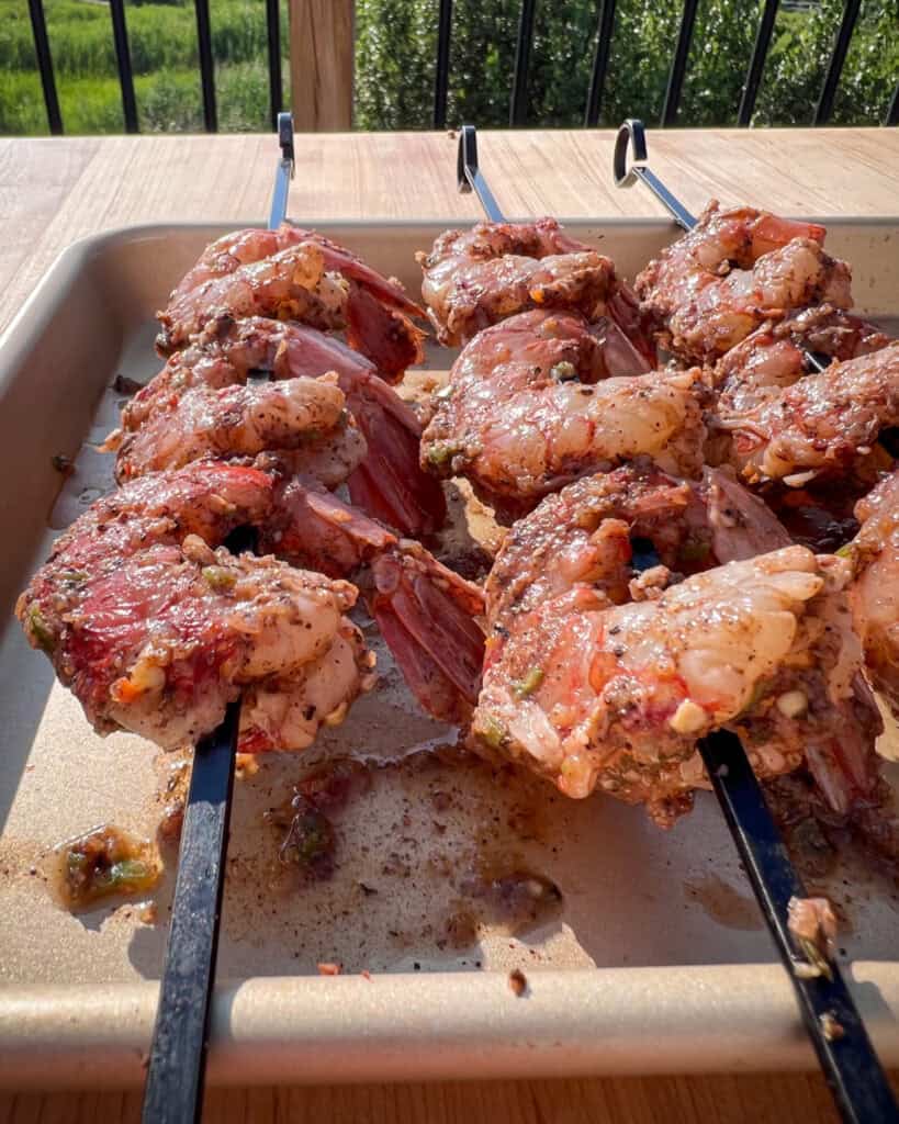 Three marinated jerk shrimp skewers.