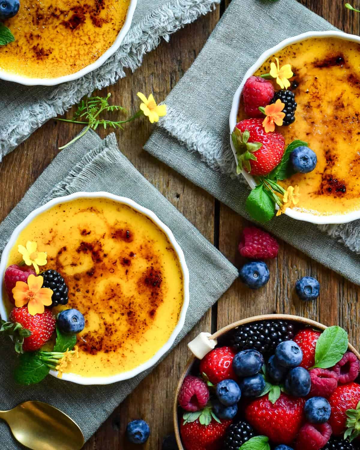 Garnish Crème Brûlée with fresh berries, mint and edible
