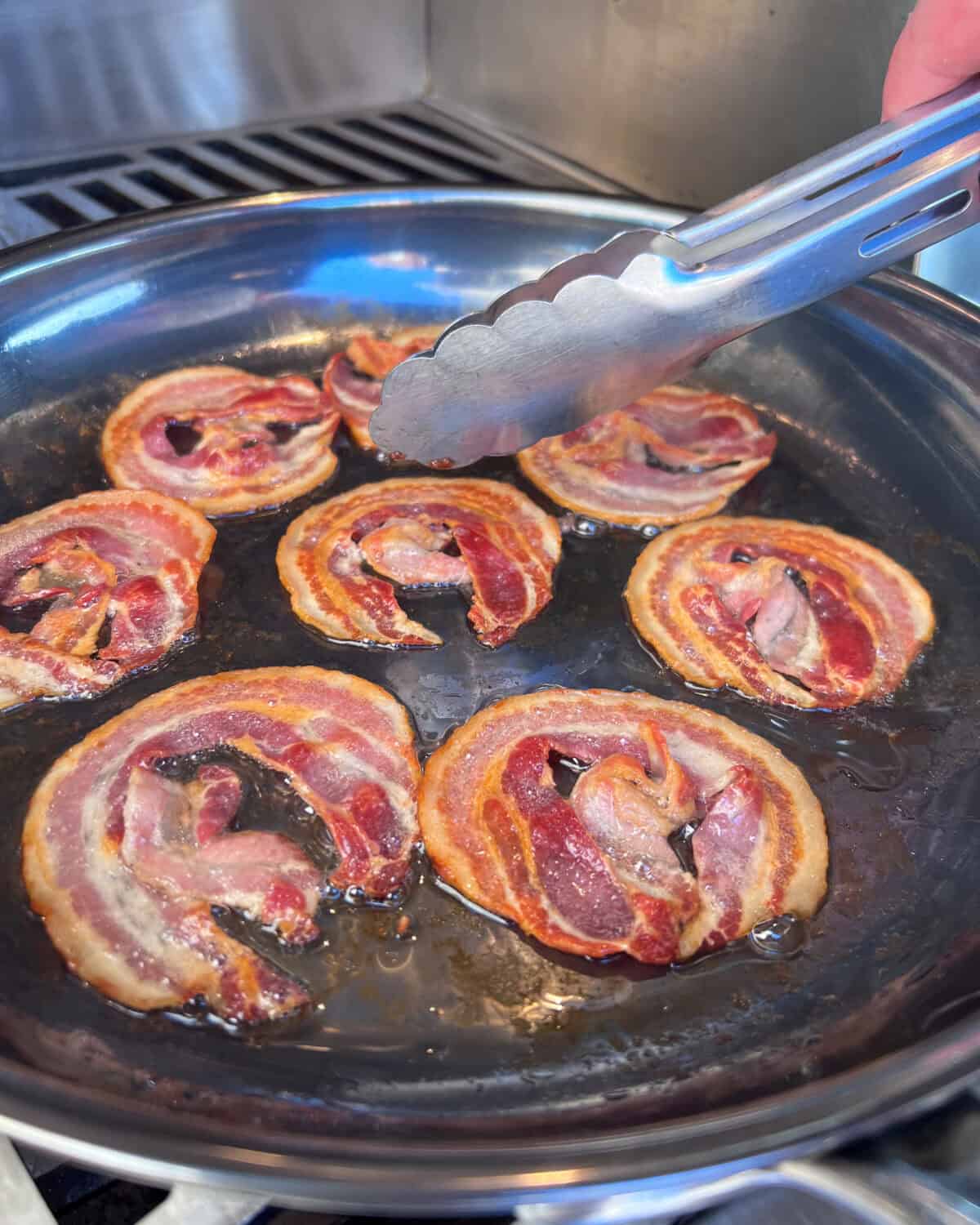 Cooking pancetta in a skillet on the grill.