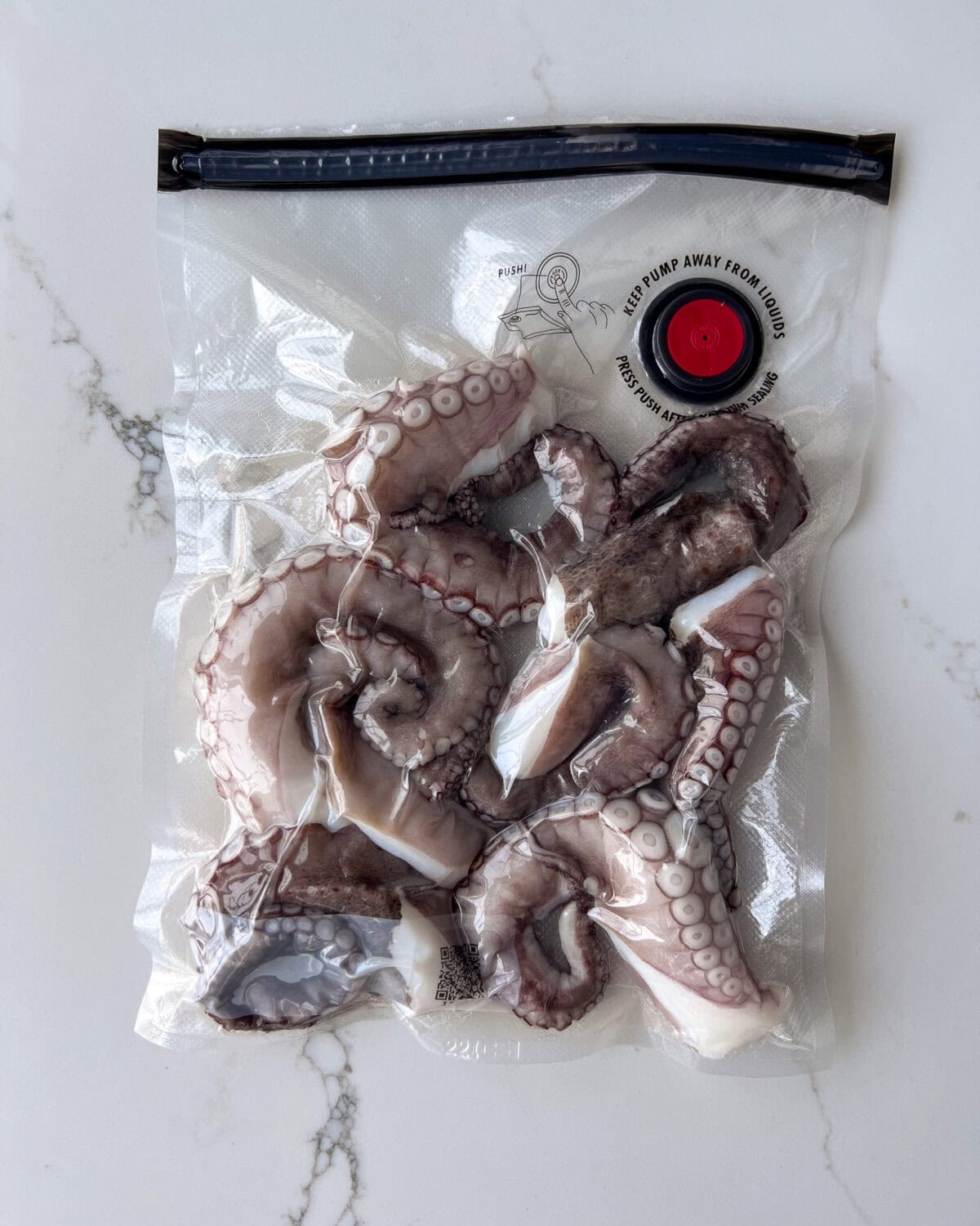 Dry the octopus tentacles, then transfer them into a vacuum seal bag. Seal the bag, then use the vacuum pump to remove the air.
