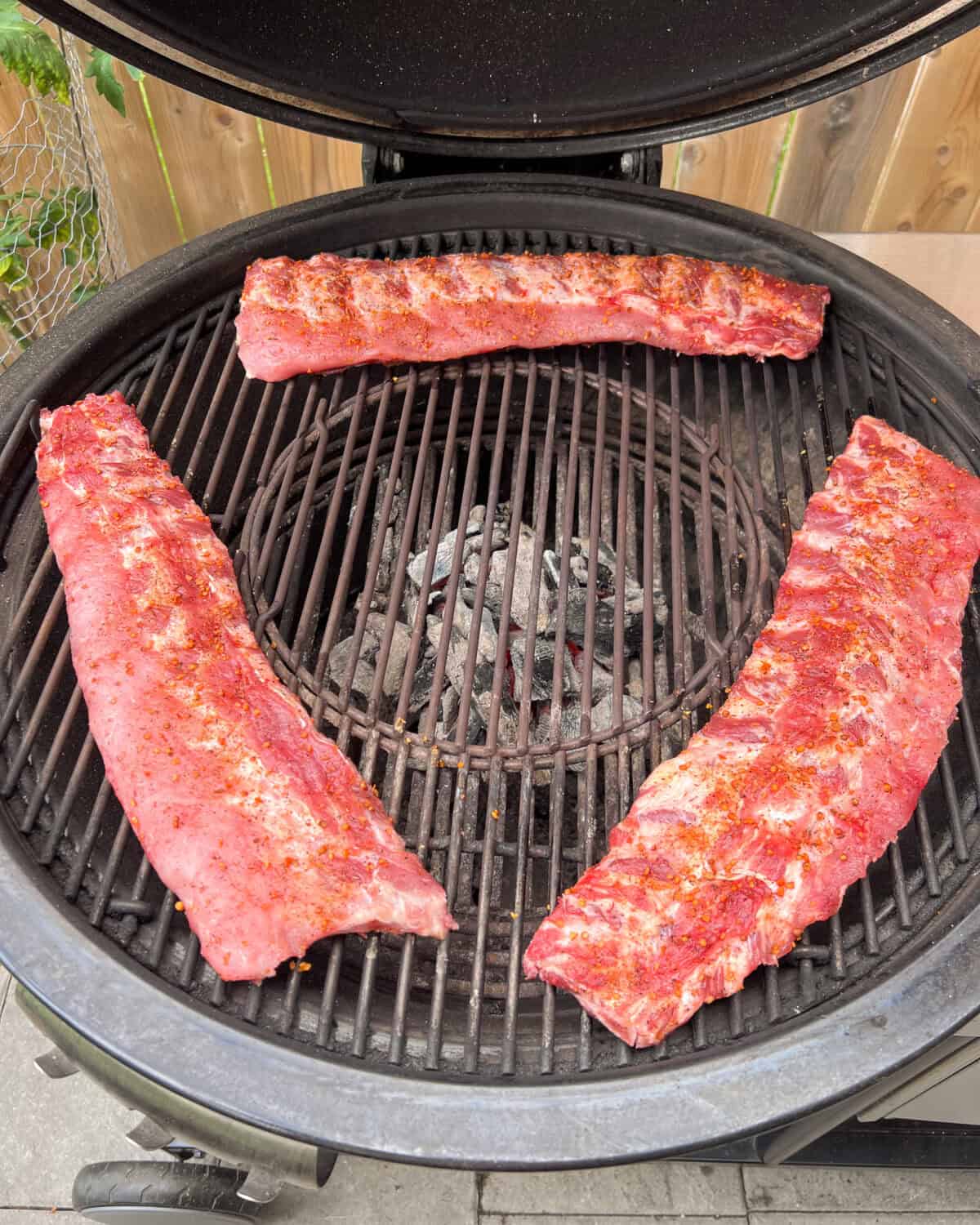 Three baby back ribs placed bone side down, over indirect heat.