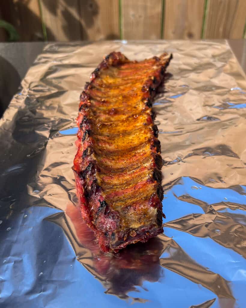 Lay the ribs meat side down on each piece of foil. Pour a 2 tablespoons apple juice over each rack of ribs.