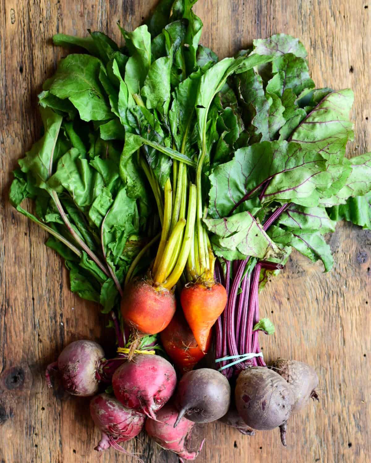 A beautiful stack of 3 varieties of beets from a farmers market: golden beets, candy-can beets and red beets.