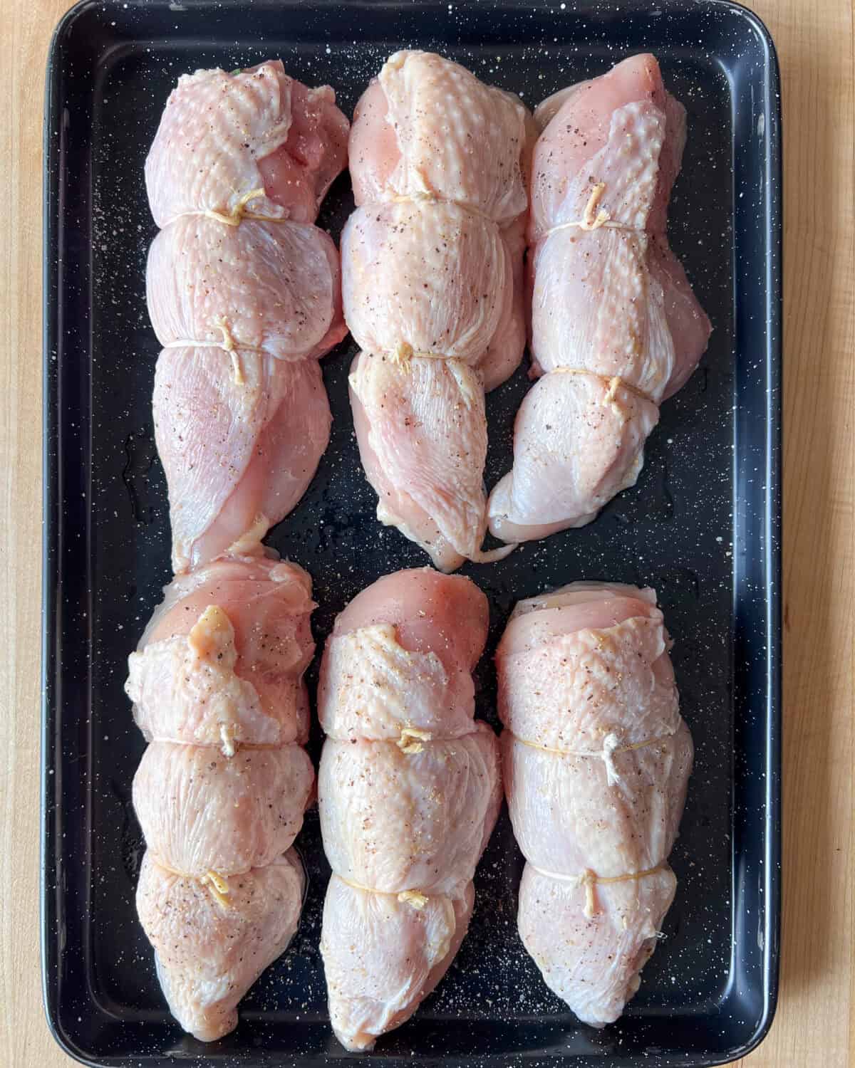 Six wrapped chicken breasts. Using two pieces of butcher’s twine, tie the chicken breast closed.