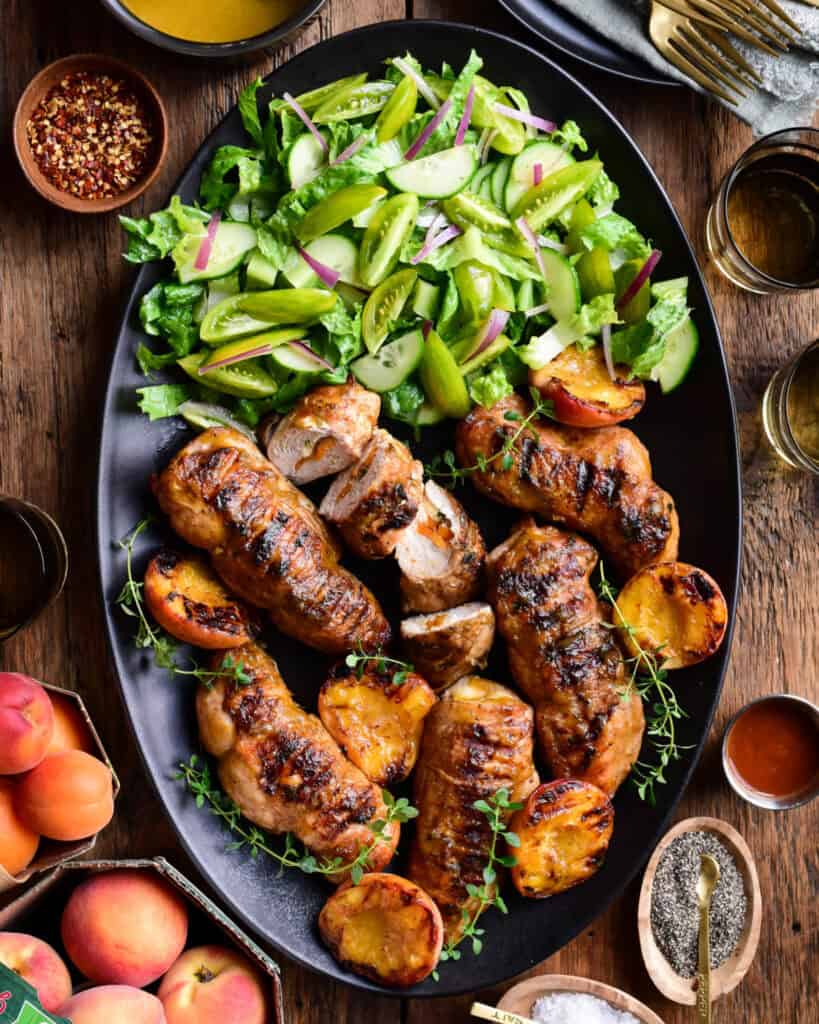 A larger platter of (Stuffed) Chicken Breasts with Peach BBQ Sauce and a green salad.