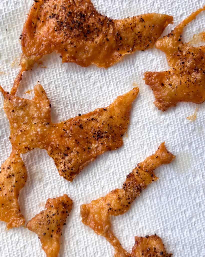 Crispy chicken skins drying on paper towel.