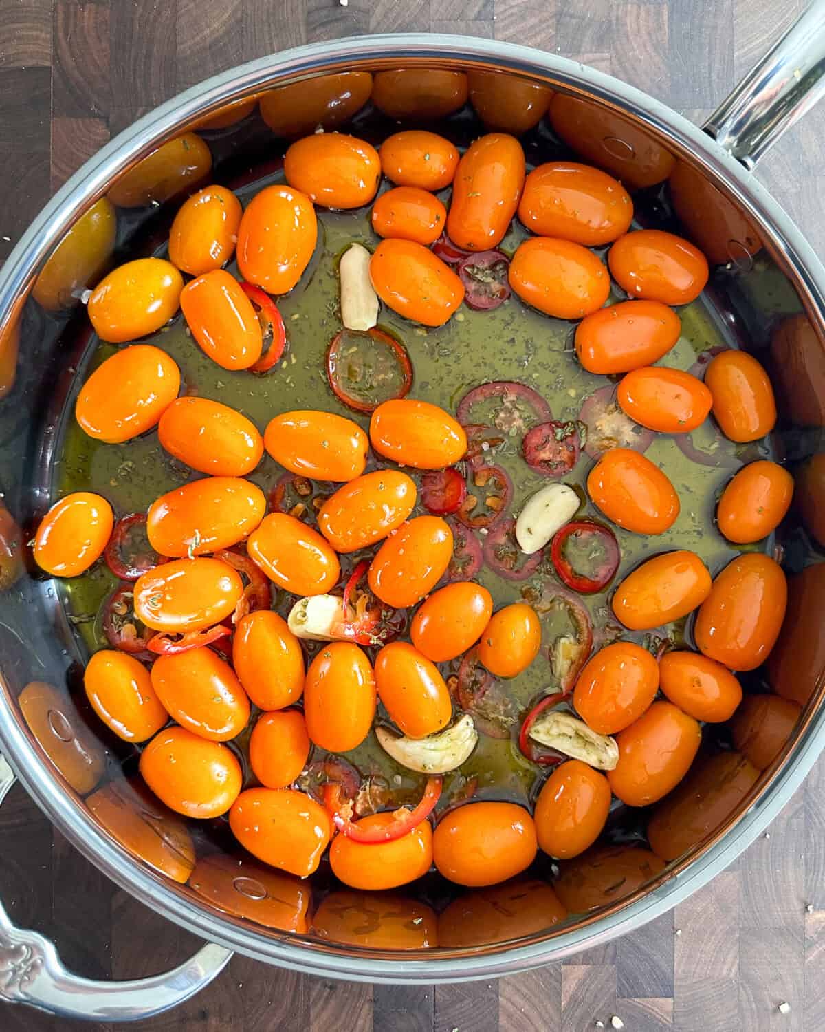Tomatoes, garlic, oregano, jalapeno and olive oil in a pan.