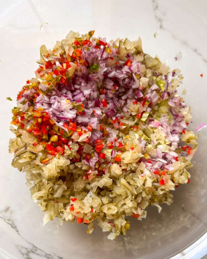 A bowl of finely chopped vegetables and pickles for a chopped Italian sandwich recipe.