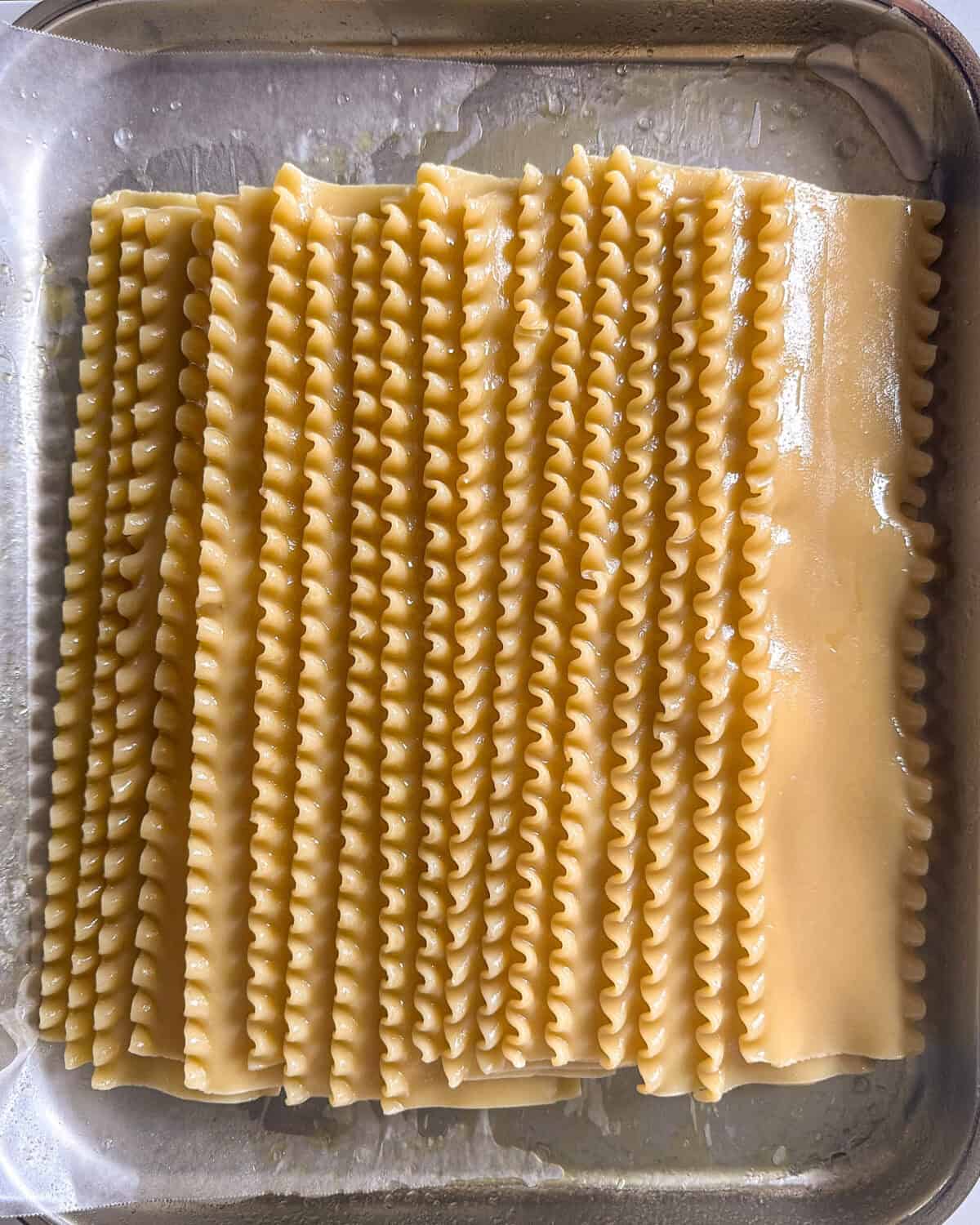 Lasagna sheets sprayed with olive oil and layed out on a sheet pan.