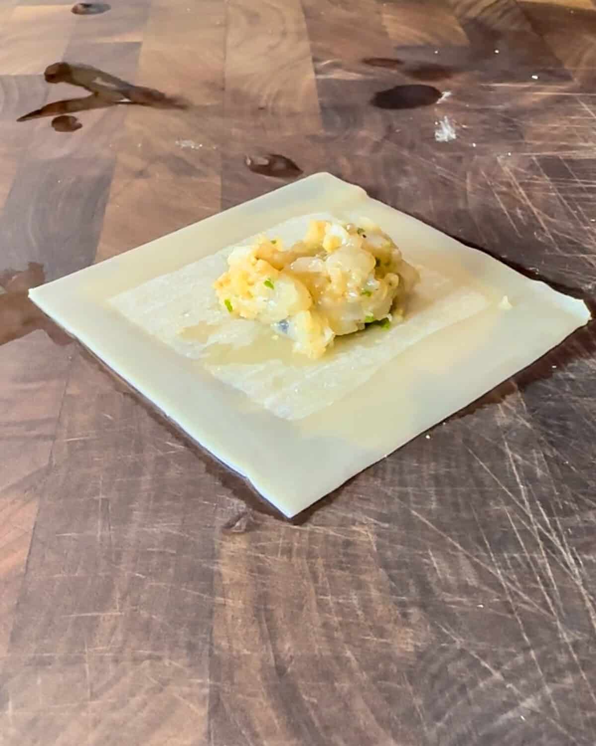 Place a teaspoon of the prepared filling in the center of the wonton wrapper.