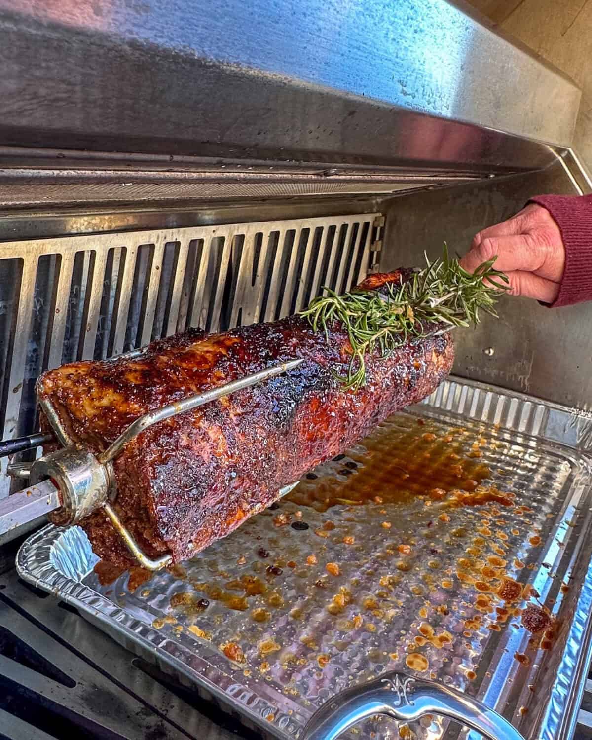 Basting the roast with a rosemary brush.