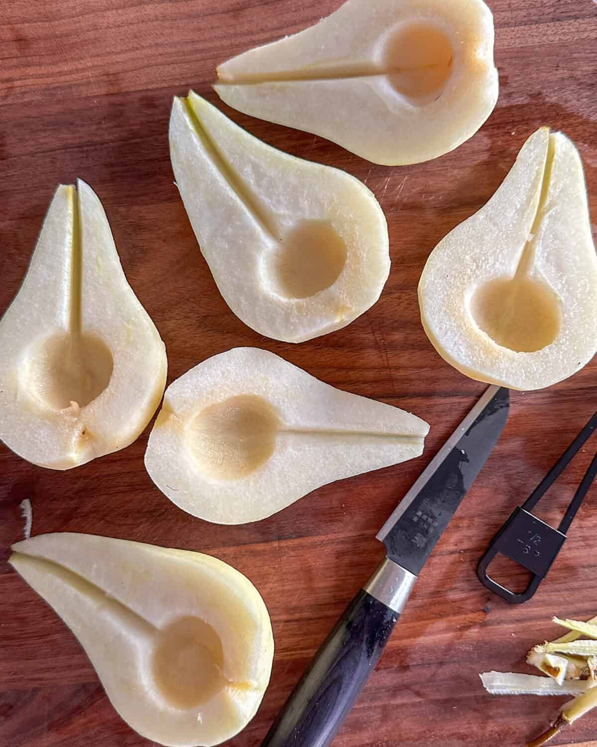 Using a melon baller or measuring spoon, scoop out the seeds of each pear half. Using a paring knife slice out the fibrous internal stem.