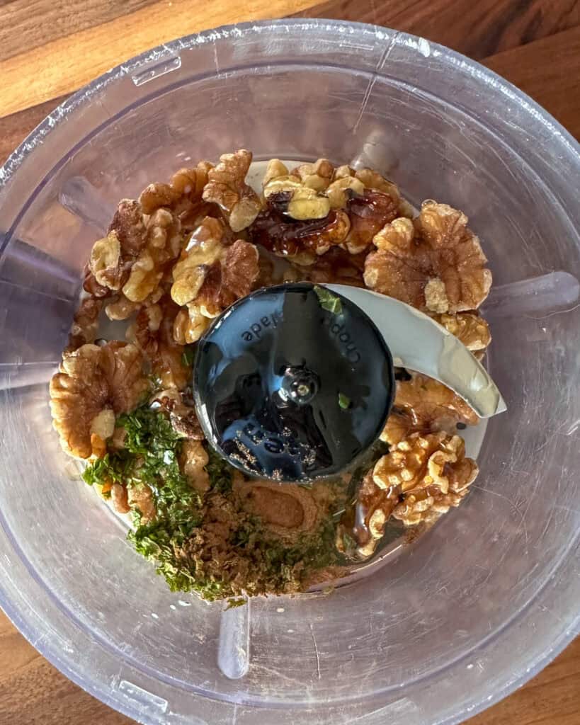 Walnut ingredients in a food processor about to get pulsed.