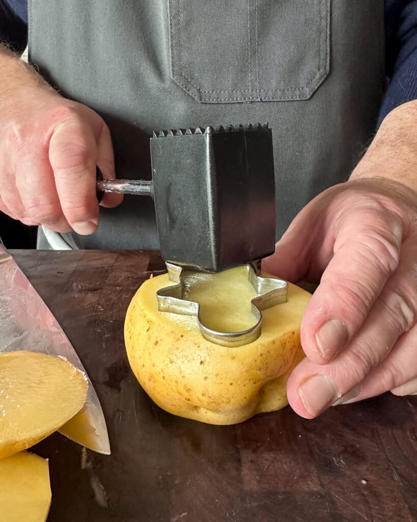 Place the cutter on top of the potatoes and using a kitchen mallet (or bottom of a can), bang the cutter deep into the potato.