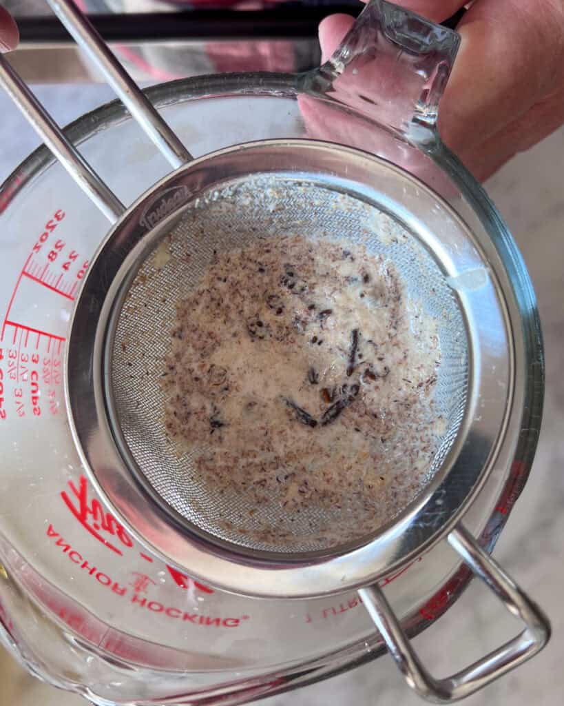 Place a fine-mesh strainer over a large liquid measuring cup, then strain the cream mixture to remove the solids.