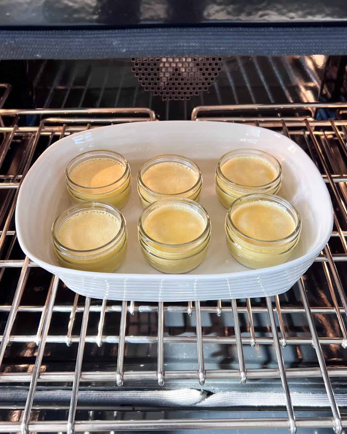 Place the mason jars into a baking dish, then fill the dish with boiling water halfway up the sides of the mason jars.
