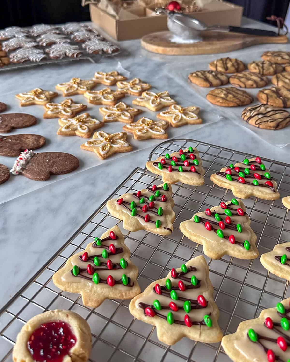 Decorated sugar cookies on racks and parchment paper.