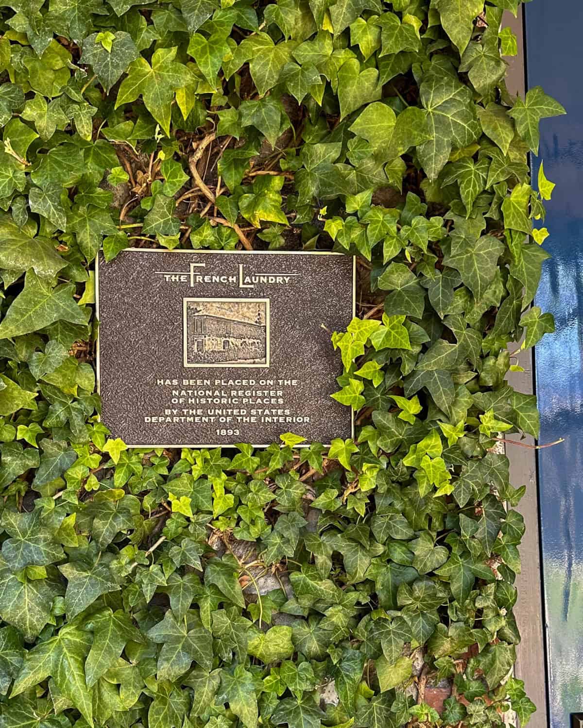 The French Landry sign - historical plaque on the ivy-covered façade.