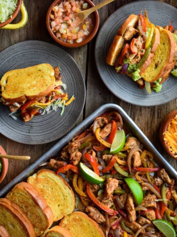Two plated fajitas on Furlani garlic toast and a sheet pan of chicken fajitas and toast.