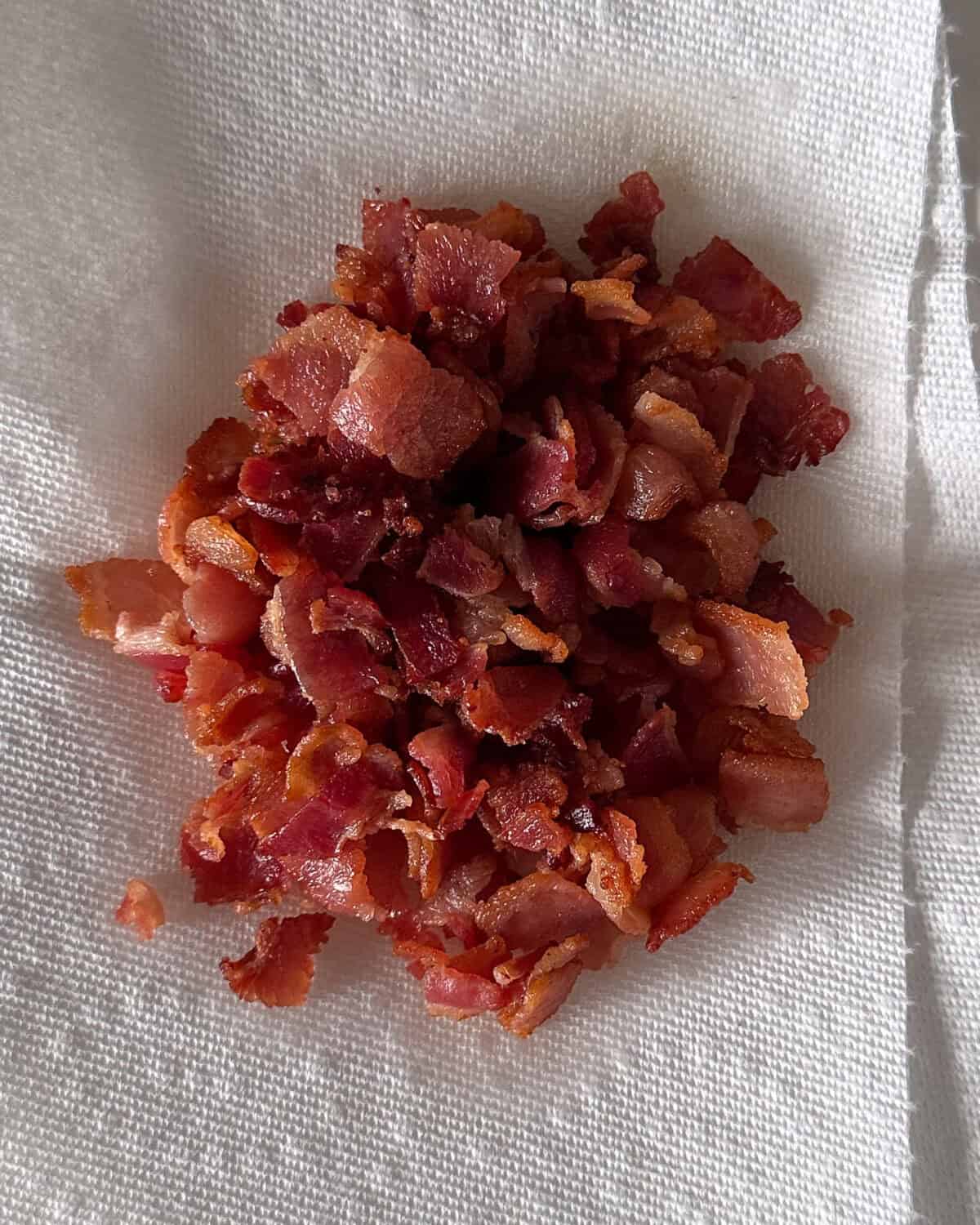 Once the bacon is cooked, use a slotted spoon to remove the bacon to a paper towel lined plate.