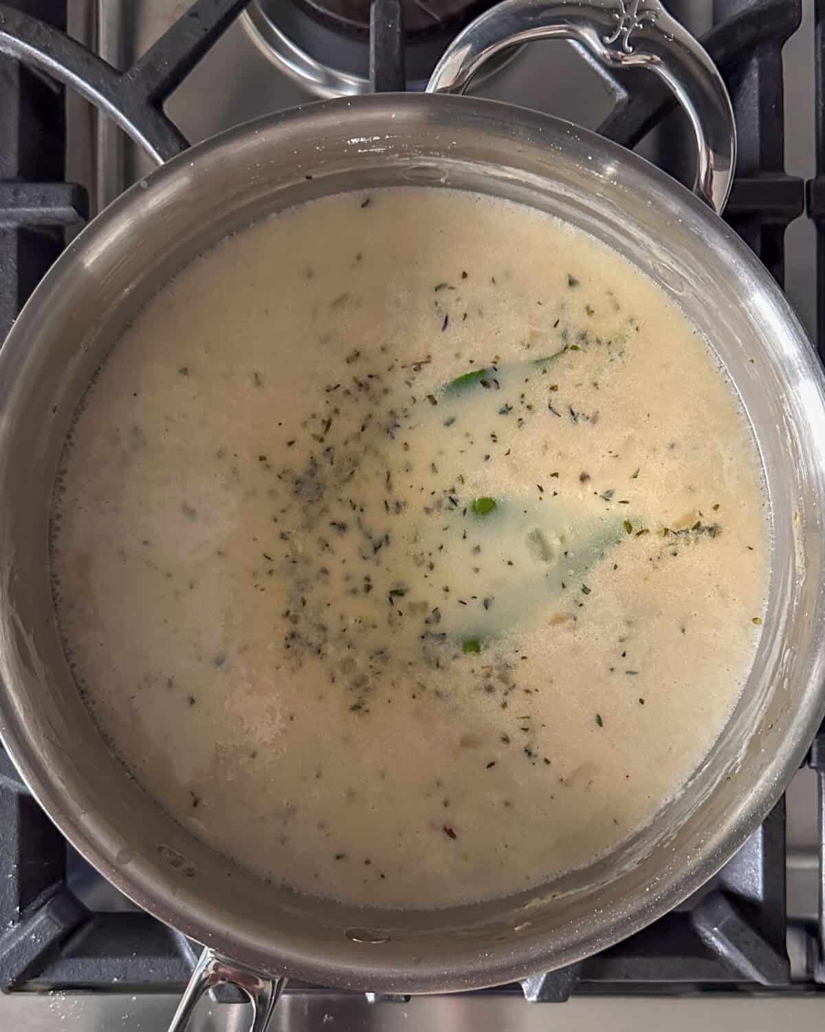Add the bay leaves, the reserved juice from the canned clams and the 8-ounce bottle of clam juice to the saucepan.