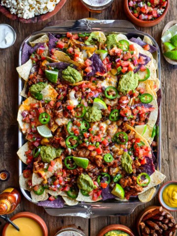 A tray of colourful and loaded chili cheese nachos.