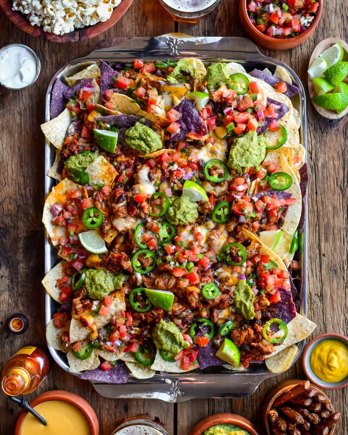 A tray of colourful and loaded chili cheese nachos.