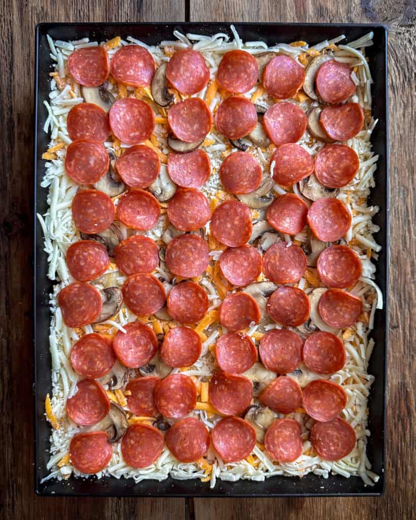 Layering a DSP with cheese, mushrooms and pepperoni.