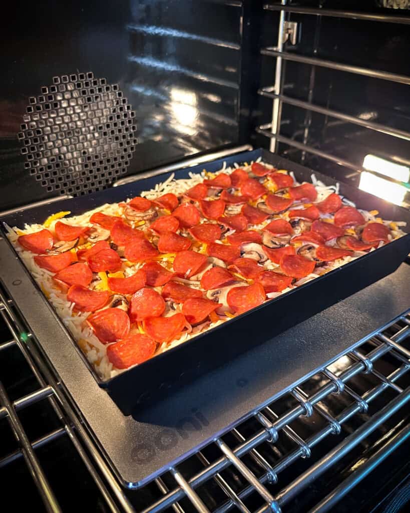 A Detroit-Style Pizza in oven on a baking steel.