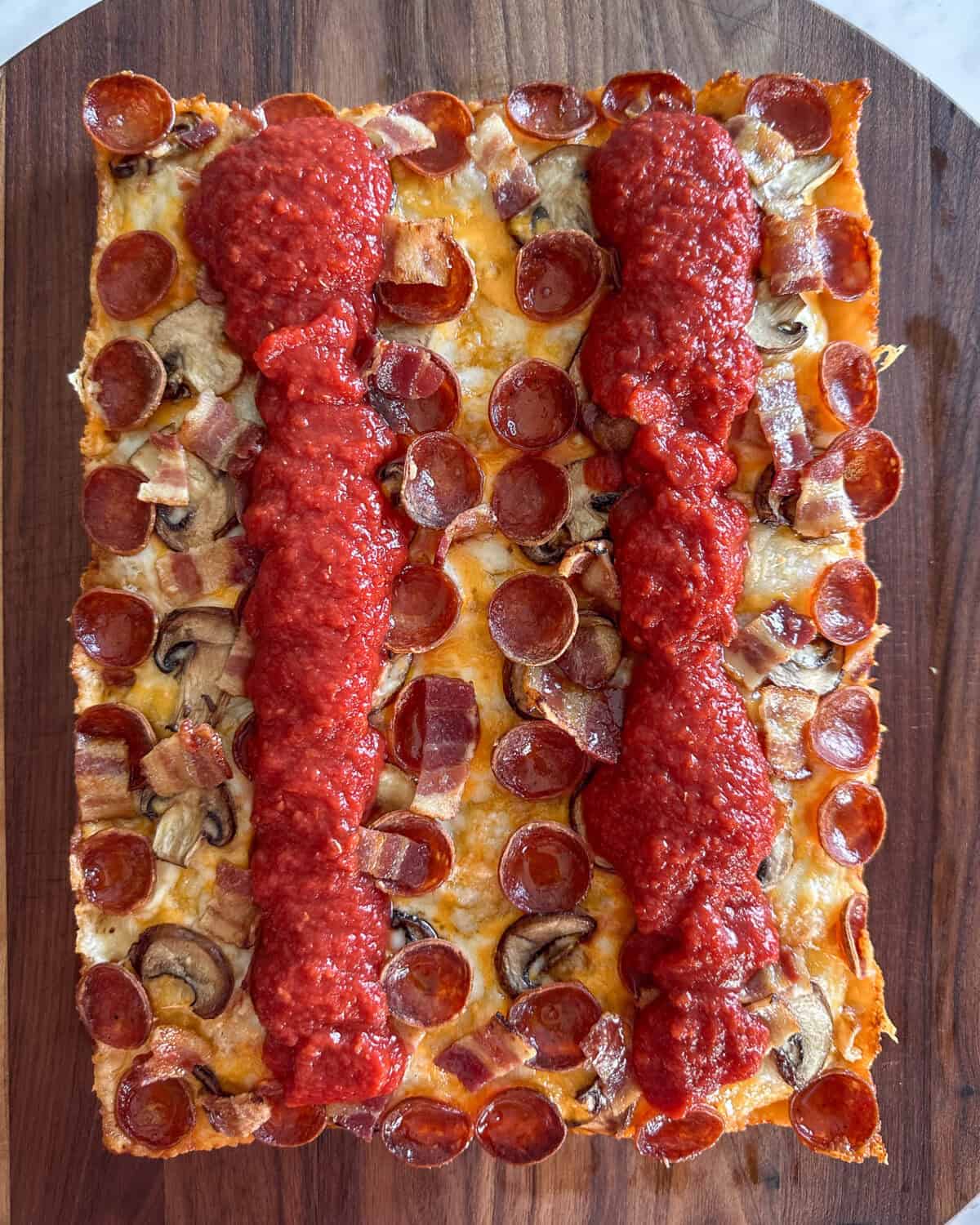 Tomato sauce ladled in two stripes across the DSP pizza.