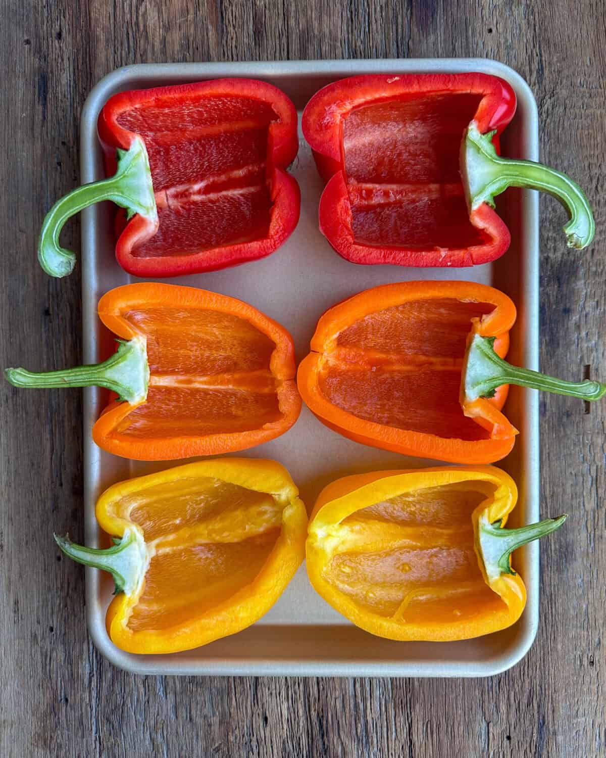 Six halves of bell peppers (three colours) cleaned out and ready to stuff.