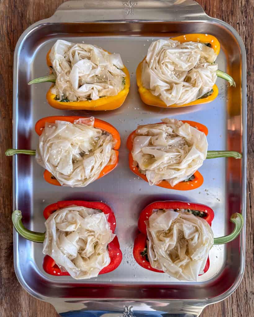 Six stuffed peppers with phyllo roses ready to be baked.